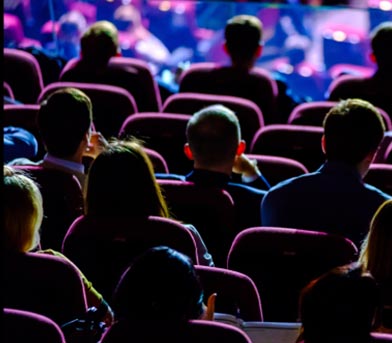An audience in auditorium seating seen from behind