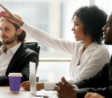 A person sitting at a board room table pointing