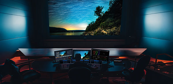 A person working at a production computer setup in a control room