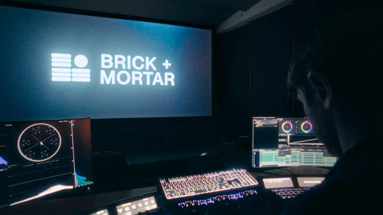 A spacious cinema lobby featuring a large LED screen and video walls, creating an inviting atmosphere for visitors.