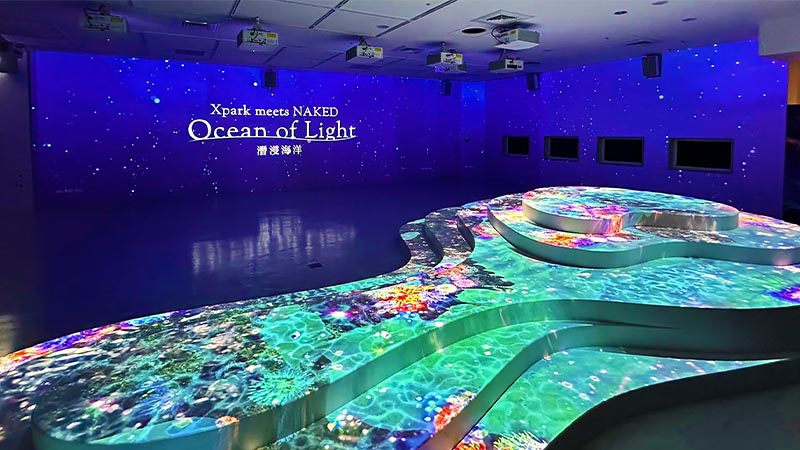 Large projections on the walls and on an elevated structure in the lobby area of the 'Ocean of Light' Exhibition