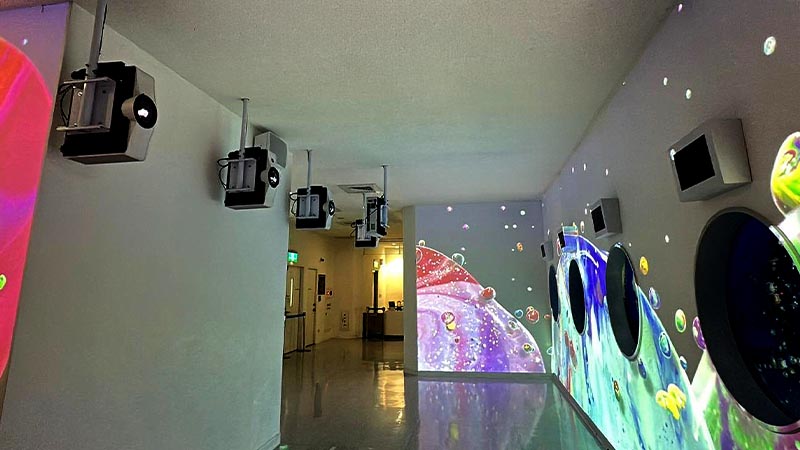 A room adorned with bright, colorful projections from several ceiling-mounted projectors, enhancing the space's visual appeal.