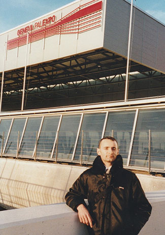 A man stands in front of a large building with the words &ldquo;Geneva Palexpo&rdquo; on the front.