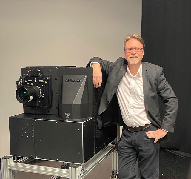 the inner perimeter of an ornate glass dome illuminated with different colours and patterns.