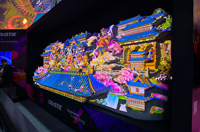 A large 3D structure that is inspired by ancient Chinese artifacts and architecture is projection mapped with vivid colors.