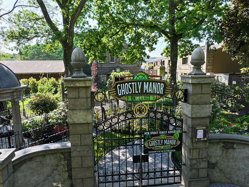 An exterior shot of a grey stone building with a landscaped yard.