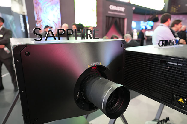 Close-up of a Sapphire 4K4p-RGBH projector seen from the front on a convention room floor.