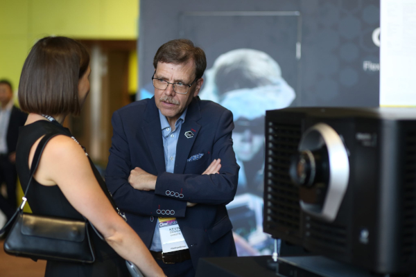 A man and a woman conversing beside a digital cinema projector.